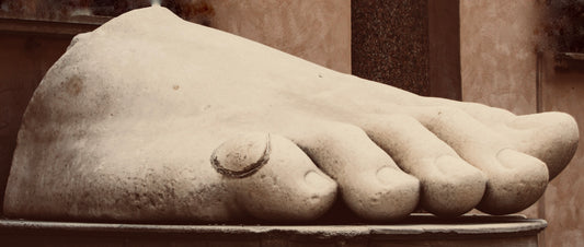 Stone sculpture of a foot with detailed toes on a pedestal